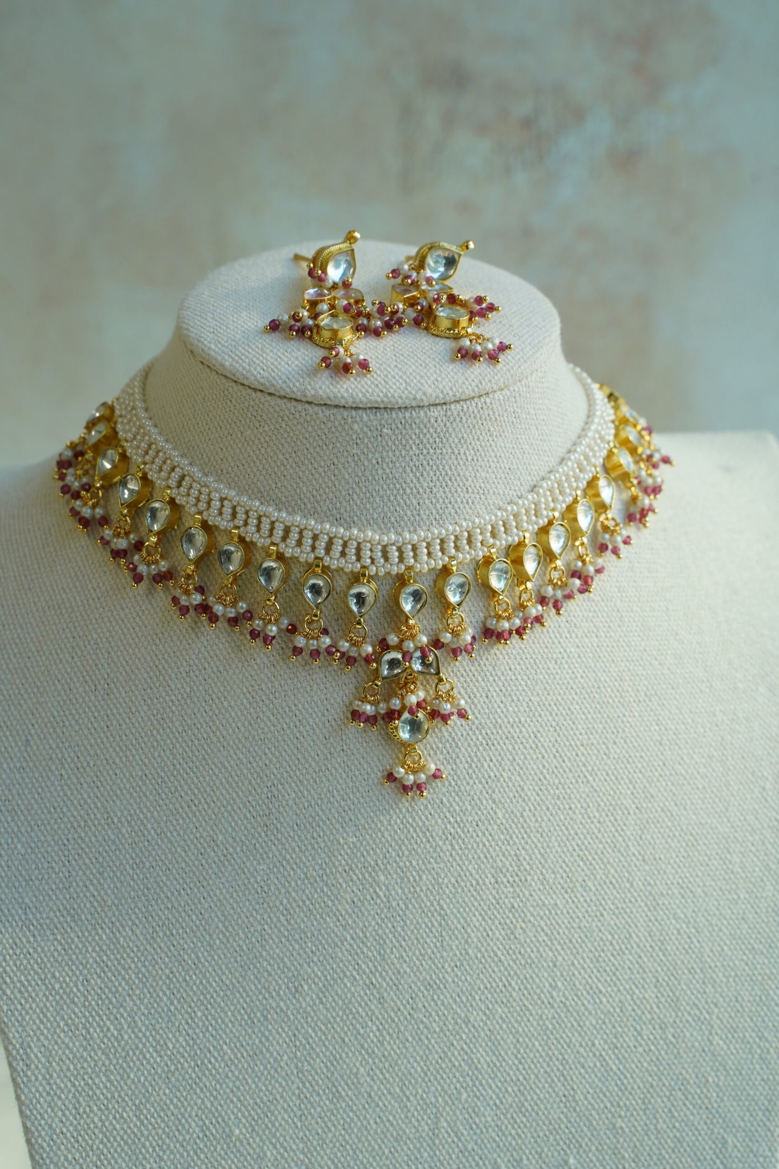 Small pachi necklace set with woven beaded neckline, clear teardrop stones, wine red bead drops, and matching earrings