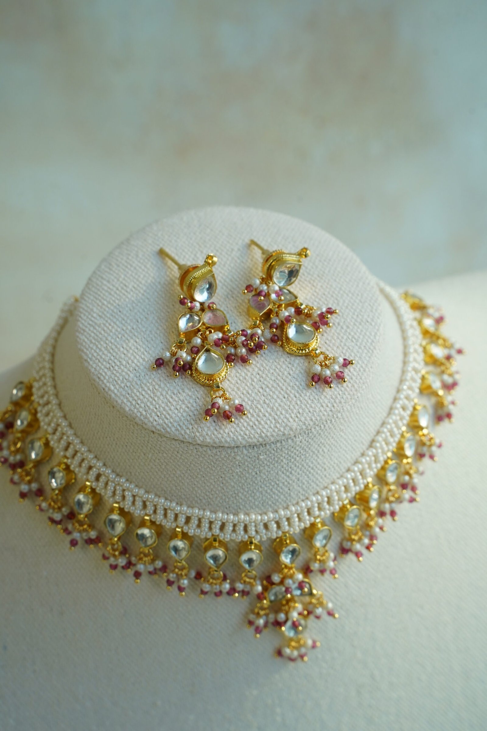 Small pachi necklace set with woven beaded neckline, clear teardrop stones, wine red bead drops, and matching earrings