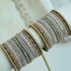 Soft pastel blush pink and blue stacked bangle set with beaded edges, stone strips, and antique gold bangles with pink oval stones
