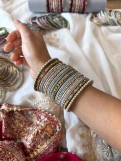 Soft pastel blush pink and blue stacked bangle set with beaded edges, stone strips, and antique gold bangles with pink oval stones