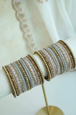 Soft pastel blush pink and blue stacked bangle set with beaded edges, stone strips, and antique gold bangles with pink oval stones