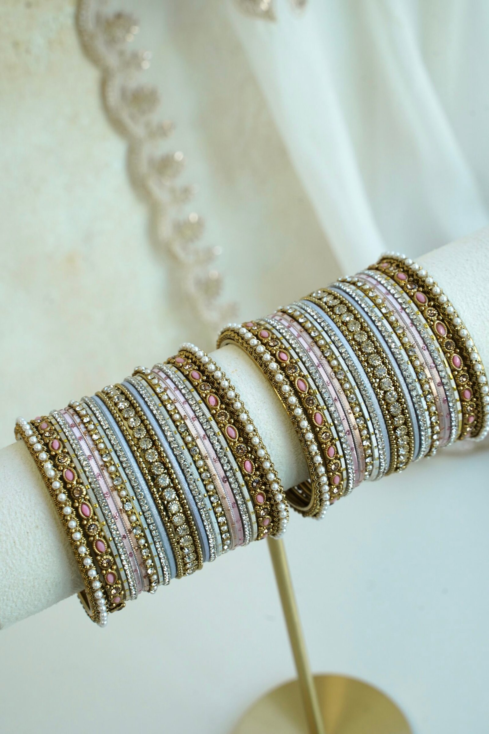 Soft pastel blush pink and blue stacked bangle set with beaded edges, stone strips, and antique gold bangles with pink oval stones