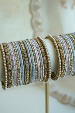 Soft pastel blush pink and blue stacked bangle set with beaded edges, stone strips, and antique gold bangles with pink oval stones