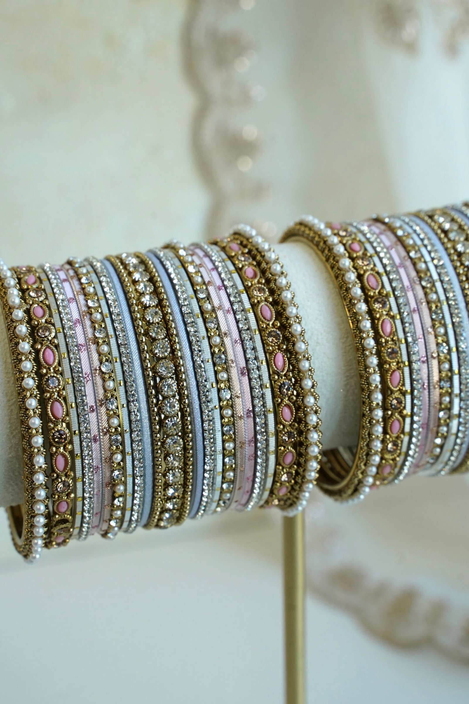 Soft pastel blush pink and blue stacked bangle set with beaded edges, stone strips, and antique gold bangles with pink oval stones