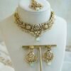 Somya pastel beaded artificial kundan set with mint and pink beads, antique gold necklace, matching earrings and tikka displayed on a bust