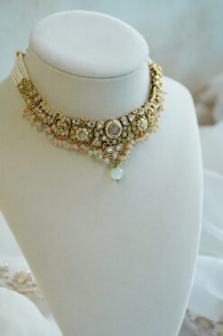 Somya pastel beaded artificial kundan set with mint and pink beads, antique gold necklace, matching earrings and tikka displayed on a bust
