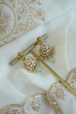 Somya pastel beaded artificial kundan set with mint and pink beads, antique gold necklace, matching earrings and tikka displayed on a bust