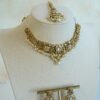 Somya white beaded artificial kundan set with antique gold necklace, pearl-style beads and clear stones, matching earrings and tikka displayed on a bust