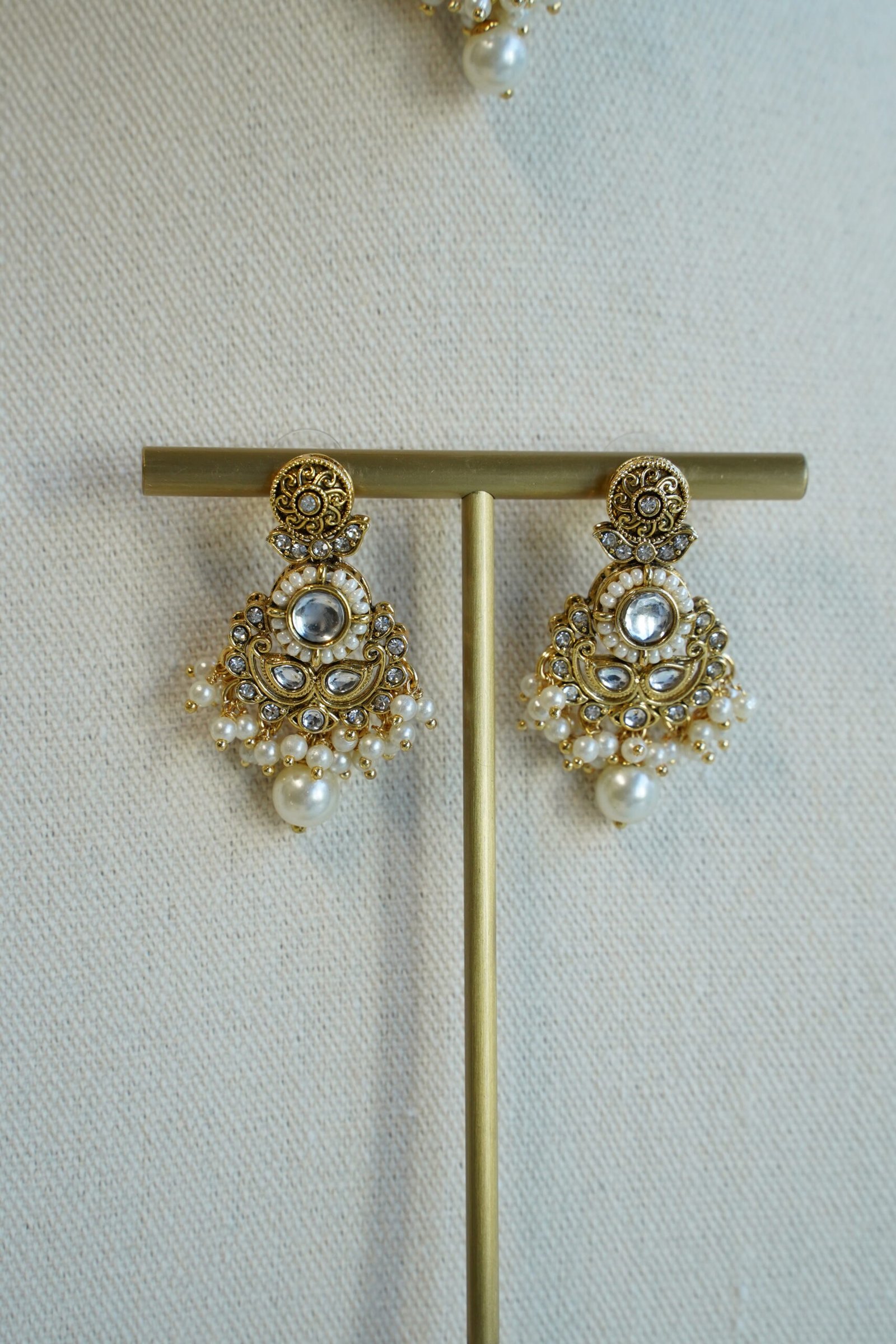 Somya white beaded artificial kundan set with antique gold necklace, pearl-style beads and clear stones, matching earrings and tikka displayed on a bust