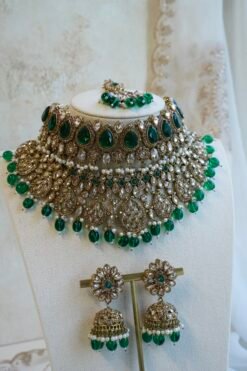 Zeenat green bridal set with layered choker necklace, jhumar, jhumka earrings, and tikka in antique gold tone