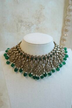 Zeenat green bridal set with layered choker necklace, jhumar, jhumka earrings, and tikka in antique gold tone