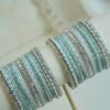 Silver blue stacked bangle set with aqua blue and white bangles, silver tone stone strips, and beaded edges